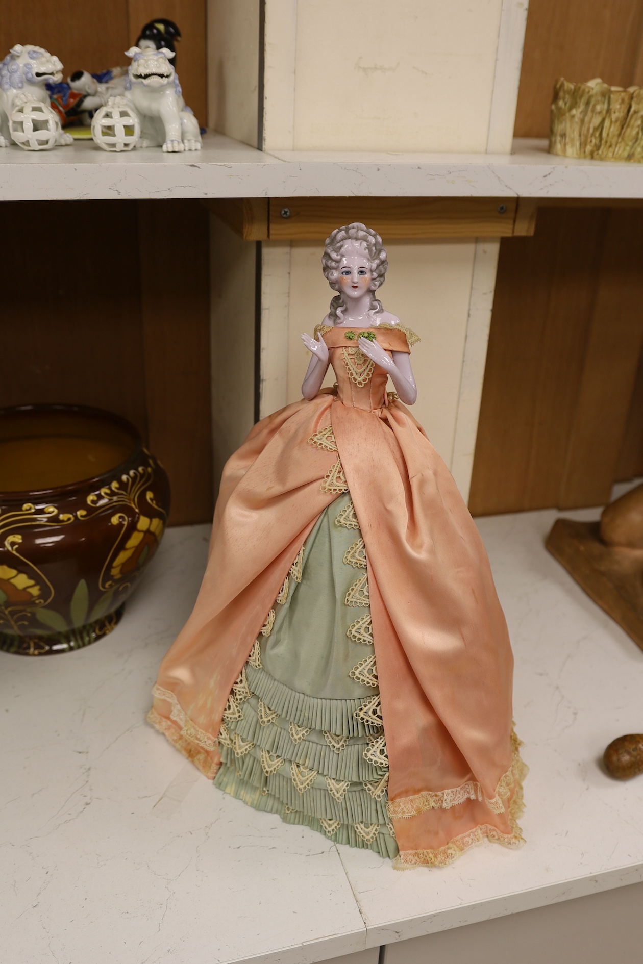 A 1920’s German porcelain 'pin dolly' with tea cosy dress, 46cm high. Condition - good some marks to the silk of cosy/dress